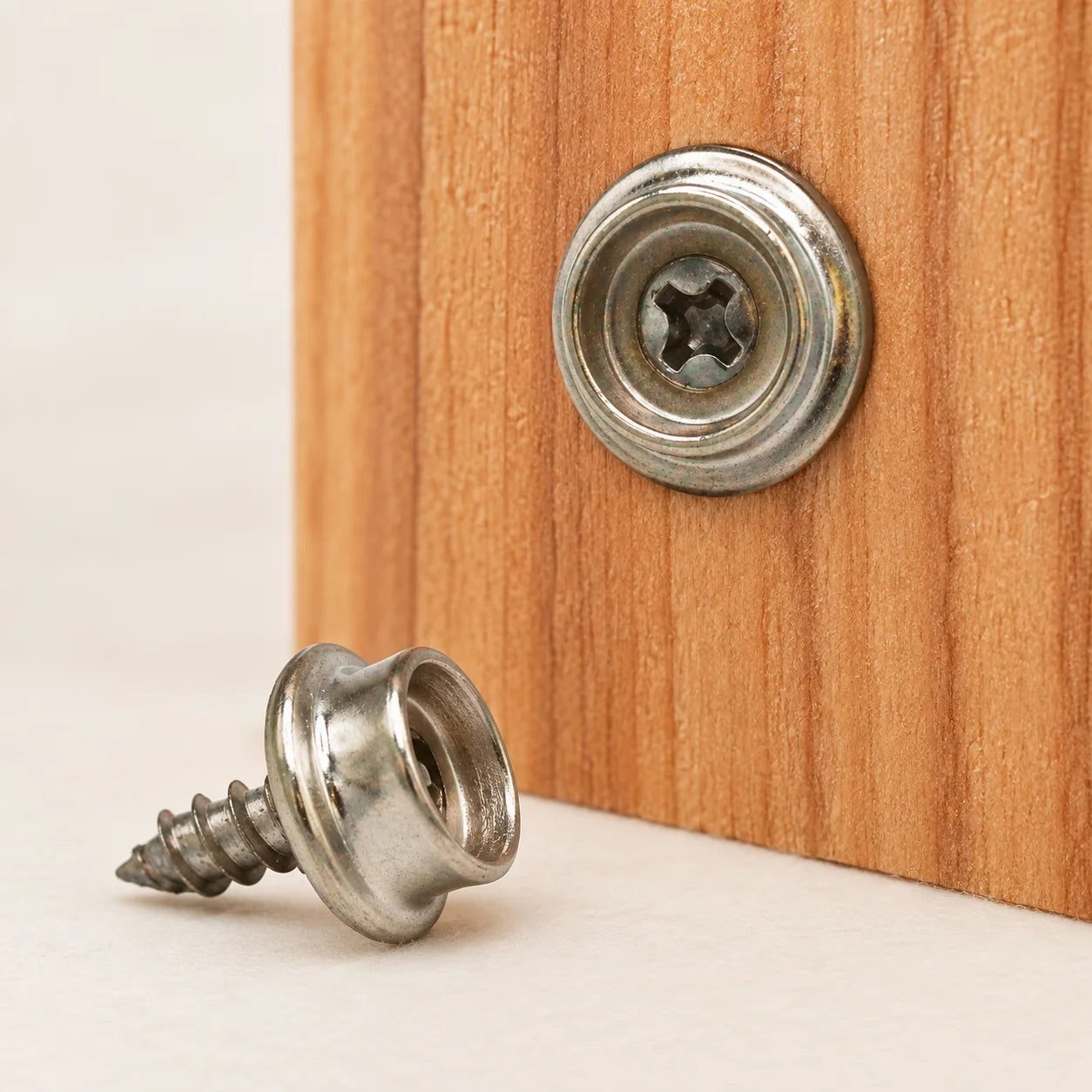 Small silver wind snaps secured to the wooden sauna base